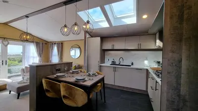 a kitchen with a table and some chairs in it at 1 Sunset View in Millom