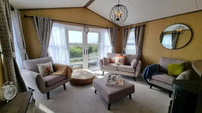 a living room with chairs and a large window at 1 Sunset View in Millom