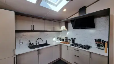 a kitchen with white cabinets and a sink and a skylight at 1 Sunset View in Millom