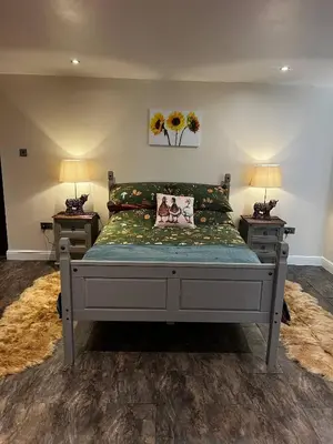 a bedroom with a bed with two night stands and two lamps at Charming Retreat with Sauna, Dog Swimming Pool, and Rural Charm in Leyland