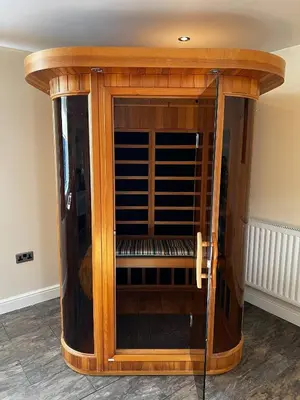 a large wooden display cabinet with a glass door at Charming Retreat with Sauna, Dog Swimming Pool, and Rural Charm in Leyland