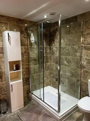 a shower with a glass door in a bathroom at Charming Retreat with Sauna, Dog Swimming Pool, and Rural Charm in Leyland
