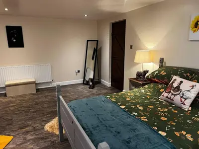a bedroom with a bed with a green comforter at Charming Retreat with Sauna, Dog Swimming Pool, and Rural Charm in Leyland
