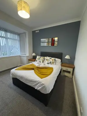 a bedroom with a bed with a yellow blanket on it at Hillside Stays - Cosy 2 Bed Bungalow, Pet Friendly in Blackpool