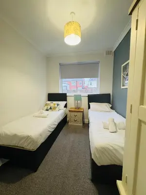 a bedroom with two beds and a window at Hillside Stays - Cosy 2 Bed Bungalow, Pet Friendly in Blackpool
