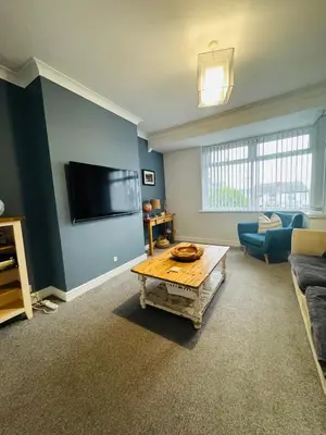 a living room with a couch and a tv on a wall at Hillside Stays - Cosy 2 Bed Bungalow, Pet Friendly in Blackpool