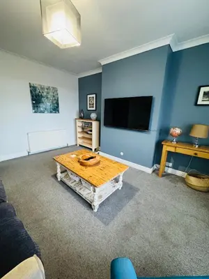 a living room with a table and a flat screen tv at Hillside Stays - Cosy 2 Bed Bungalow, Pet Friendly in Blackpool