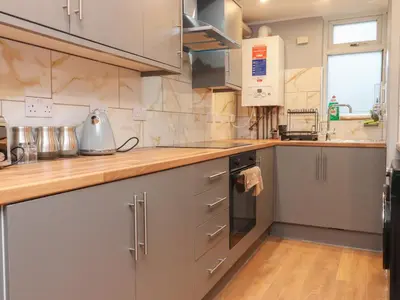 a kitchen with stainless steel appliances and wooden counter tops at Morcombe Retreat in Morecambe