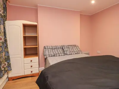 a bedroom with a bed and a white cabinet at Morcombe Retreat in Morecambe