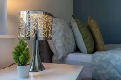 a lamp sitting on a table next to a bed at The Kensington House in Liverpool