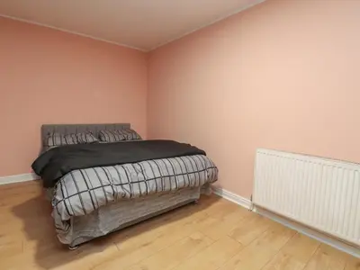 a bedroom with a bed in a room with pink walls at West End Retreat in Morecambe