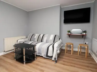 a living room with a couch and a flat screen tv at West End Retreat in Morecambe