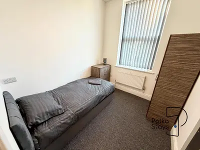 a bedroom with a bed and a window at Spacious Ormskirk Contractor Stay by PolkaStays in Ormskirk