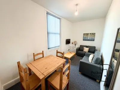 a living room with a table and a couch at Spacious Ormskirk Contractor Stay by PolkaStays in Ormskirk