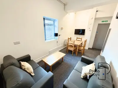 a living room with a couch and a table at Spacious Ormskirk Contractor Stay by PolkaStays in Ormskirk