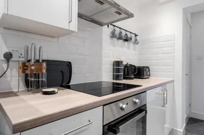 a kitchen with a stove and a counter top at Cosy Anfield Home in Liverpool