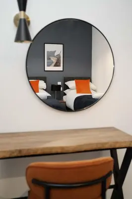 a mirror over a table with a bed in a bedroom at Cosy Anfield Home in Liverpool
