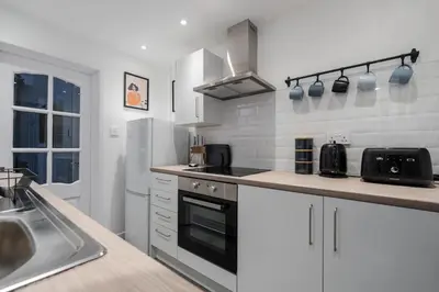 a kitchen with a sink and a stove top oven at Cosy Anfield Home in Liverpool