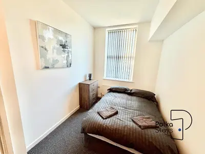 a bedroom with a bed and a window at Sleeps 10 Spacious for Contractors by PolkaStay in Ormskirk