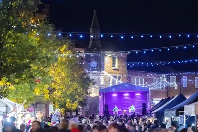 a crowd of people in front of a building with lights at Sleeps 10 Spacious for Contractors by PolkaStay in Ormskirk