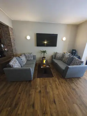 a living room with two couches and a tv at The Lenbrook in Blackpool