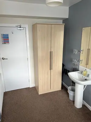 a bathroom with a sink and a toilet and a cabinet at The Lenbrook in Blackpool
