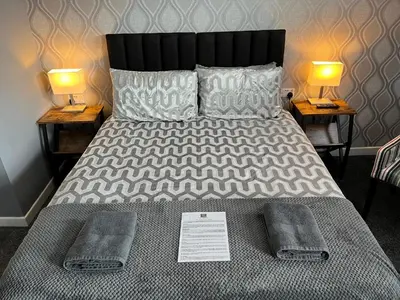 a bed with two lamps and two towels on it at The Lenbrook in Blackpool