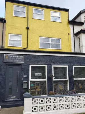 a yellow and black building with a fence in front of it at The Lenbrook in Blackpool