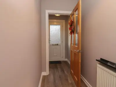 a hallway with a door and a window at Seaside Serenity in Lytham St Annes