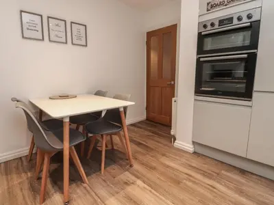 a kitchen with a table and chairs and an oven at Seaside Serenity in Lytham St Annes