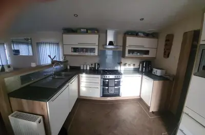 a kitchen with white cabinets and a stove top oven at 47 Venture Caravan Park in Morecambe