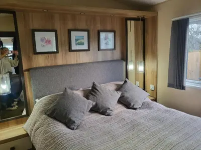 a bedroom with a bed with pillows and a mirror at 47 Venture Caravan Park in Morecambe