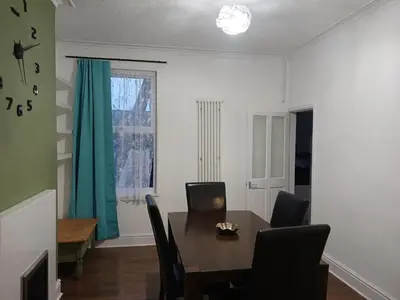 a dining room with a table and chairs and a window at Anfield Breaktime House in Liverpool
