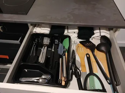 a drawer filled with utensils under a counter at Anfield Breaktime House in Liverpool
