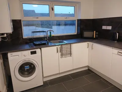 a kitchen with a washing machine and a sink at Anfield Breaktime House in Liverpool