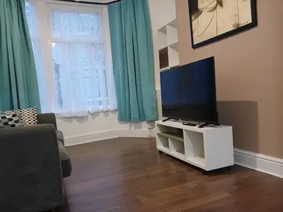 a living room with a flat screen tv on a stand at Anfield Breaktime House in Liverpool