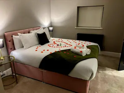 a bedroom with a large bed with flowers on it at Hamilton Luxury - The James Suite in Scorton