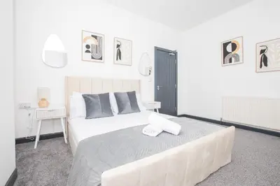 a bedroom with a large white bed with two towels on it at Cozy Liverpool Base Close to City Centre in Liverpool