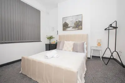 a bedroom with a large white bed with towels on it at Cozy Liverpool Base Close to City Centre in Liverpool