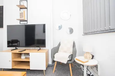 a living room with a desk and a chair and a tv at Cozy Liverpool Base Close to City Centre in Liverpool