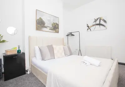 a bedroom with a white bed and a couch at Cozy Liverpool Base Close to City Centre in Liverpool
