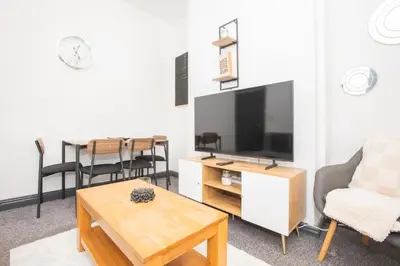 a living room with a television and a table at Cozy Liverpool Base Close to City Centre in Liverpool