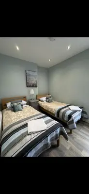 two beds in a large room with at Comfortable 2BR Home in Southport up to 6 guest in Southport