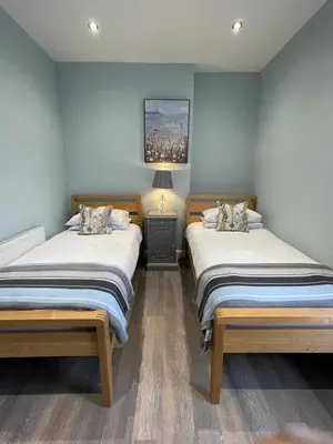two beds in a room with blue walls at Comfortable 2BR Home in Southport up to 6 guest in Southport
