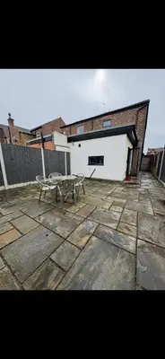 a patio with a table and a building at Comfortable 2BR Home in Southport up to 6 guest in Southport