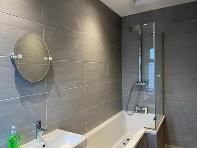 a bathroom with a tub and a sink and a mirror at Comfortable 2BR Home in Southport up to 6 guest in Southport
