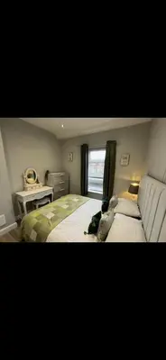 a dog laying on a bed in a bedroom at Comfortable 2BR Home in Southport up to 6 guest in Southport