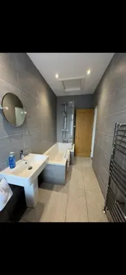 a bathroom with a tub and a sink and a bath tub at Comfortable 2BR Home in Southport up to 6 guest in Southport