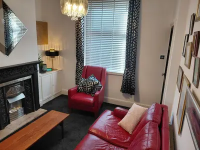 a living room with a red couch and a chair at Cottage terrace Blackpool in Blackpool