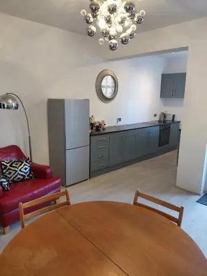 a living room with a table and a red couch at Cottage terrace Blackpool in Blackpool